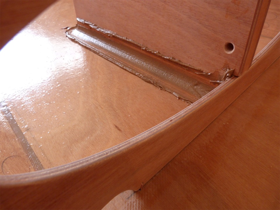 Voici le joint-congé après son lissage au tuyau PVC. Le trou à travers le pied du puits de dérive servira au passage de l'estrope qui reprend les efforts de l'écoute. Cette estrope qui tient la poulie basse d'écoute passe aussi à travers deux trous dans le bord arrière du siège central. 