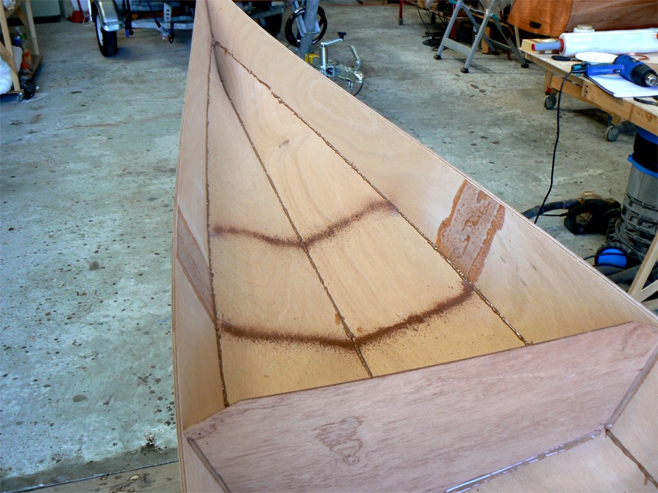 En effet, il faut maintenant (une fois que l'&eacute;poxy de ce premier collage a durci) extraire toutes les sutures et faire un second passage sur les joints, qui doivent &ecirc;tre renforc&eacute;s &agrave; la bande de tissu de verre. Vous avez manqu&eacute; le meilleur car j'avais oubli&eacute; mon appareil photo hier : la d&eacute;coupe des trappes de pontage &agrave; la scie sauteuse ! On voit sur cette image la sciure produite par la d&eacute;coupe de la trappe arri&egrave;re. 