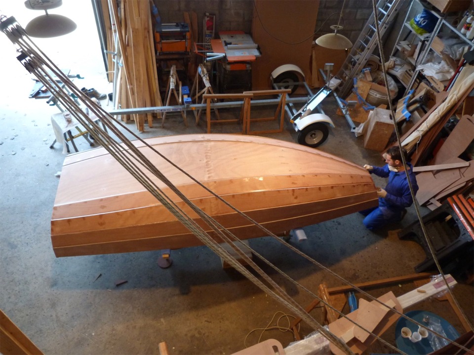 Jour 4 : nous retournons le PassageMaker Dinghy afin de "nettoyer" les collages entre les panneaux de coque que nous avions faits au soir de la premi&egrave;re journ&eacute;e. Nous allons aussi boucher tous les trous des sutures sur l'ext&eacute;rieur (comme nous l'avons fait sur l'int&eacute;rieur) et refaire une seconde couche d'&eacute;poxy charg&eacute;e sur ces joints. 