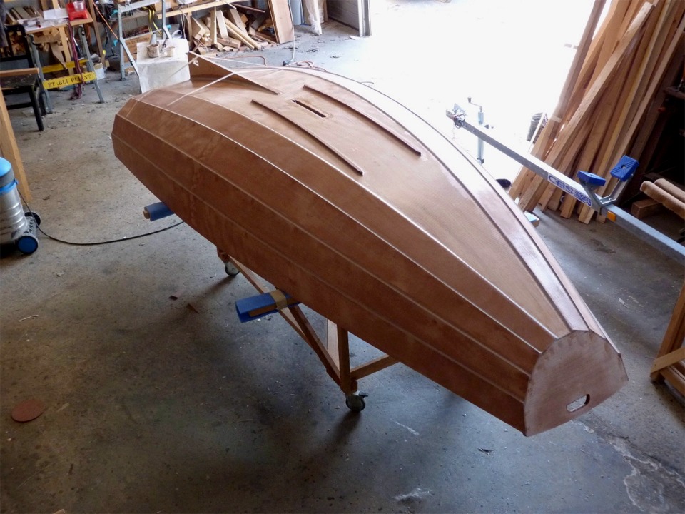 Jour 5 : Nous avons commenc&eacute; par poncer la stratification, puis nous avons ouvert le puits de d&eacute;rive &agrave; travers la sole. Nous avons ensuite pos&eacute; des bandes de fibre de verre sur les cot&eacute;s de cette ouverture afin de la renforcer, puis nous avons fix&eacute; les fausses-quilles et l'aileron. Nous avons d'abords arrondi les extr&eacute;mit&eacute;s et les ar&ecirc;tes des baguettes de sapelli qui constituent les fausses quilles, puis nous les avons fix&eacute;es avec une vis &agrave; chaque extr&eacute;mit&eacute;, en plus du collage &agrave; l'&eacute;poxy charg&eacute;e. Nous avons aussi coll&eacute; l'aileron, temporairement tenu par des bandes d'adh&eacute;sif. 