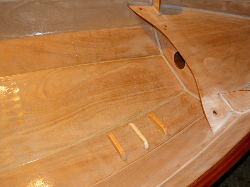 Comme pour le puits de d&eacute;rive et le pied de m&acirc;t, j'ai localis&eacute; les trous et perc&eacute; par l'int&eacute;rieur, puis frais&eacute; par l'ext&eacute;rieur de la coque. J'ai ensuite fait un premier montage "&agrave; sec", red&eacute;mont&eacute;, et je viens ici de fixer les cale-pieds b&acirc;bord apr&egrave;s avoir grassement tartin&eacute; d'&eacute;poxy "cr&egrave;me de marrons" leur base. J'ai d&eacute;ja recal&eacute; la coque pour fixer ceux de tribord. 