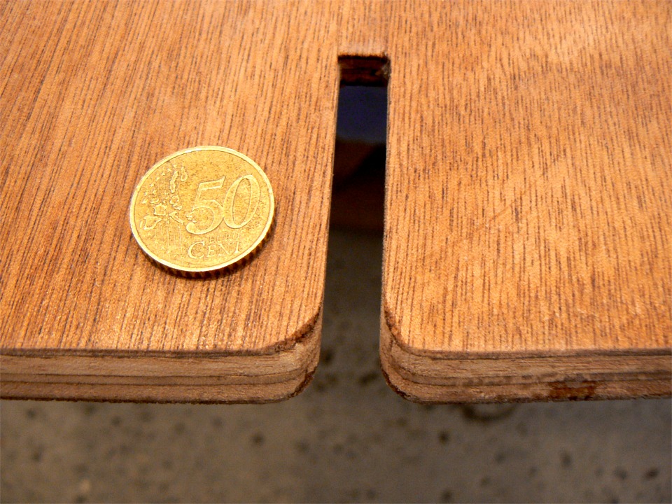 Très jolie cette pièce de 50 centimes... Elle sert à indiquer l'échelle sur cette image : il s'agit de l'une des extrémités d'un banc. La fente permet de l'encastrer sur la membrure, et j'ai arrondi les angles pour laisser la place des joints-congés bordé-membrure. J'ai également raboté/poncé le bord en fonction de l'angle du bordé. 