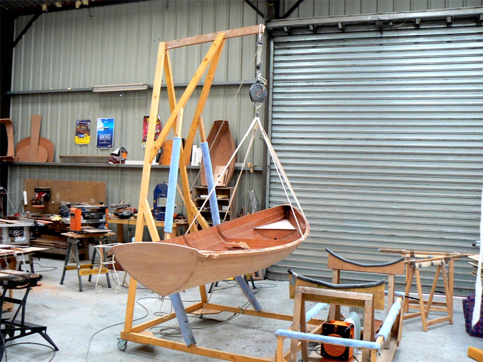 J'ai sorti la coque de la tente pour la retourner afin de finir l'ext&eacute;rieur. J'en profite pour la peser, et je suis perplexe car j'ai un surpoids d'un kilo et demi par rapport au poids th&eacute;orique du bateau fini. J'ai bien ajout&eacute; les pi&egrave;ces qui restent &agrave; poser (bancs et skeg) mais il manque encore le tissu de verre que je vais stratifier sur l'ext&eacute;rieur de la coque. Je p&egrave;se avec un peson &agrave; carpe que je vais devoir &eacute;talonner car j'ai l'impression qu'il est optimis&eacute; pour gonfler l'ego des p&ecirc;cheurs de carpe en m&ecirc;me temps que le poids de leurs prises... 