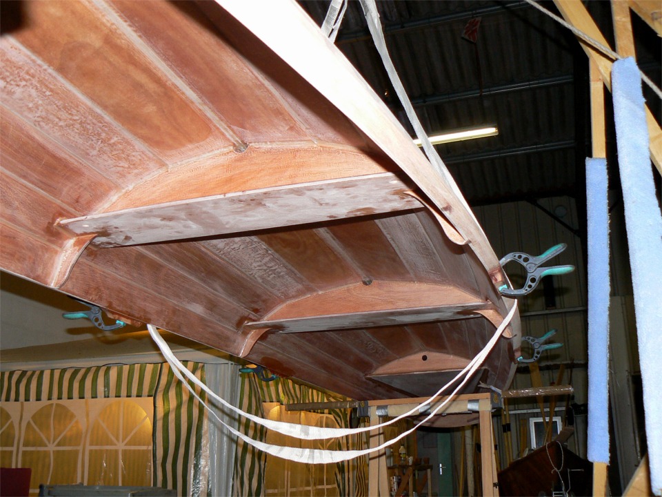 Vue de dessous, prise au flash. Les quatre pinces tiennent les sabots de dame de nage que je viens de coller. Ce wherry sera en effet équipé aussi bien pour la nage fixe en double, que pour la nage sur portant à siège coulissant. 