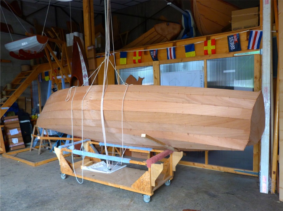 Je me d&eacute;cide enfin &agrave; aborder la partie d&eacute;licate de la manoeuvre. J'ai repos&eacute; la coque sur le chariot et fait passer le palan tribord sous la coque. Les bouts de tasseau ne servent &agrave; rien pour le moment, ils supporteront le haut du carreau lorsque j'aurai r&eacute;ussi (si, si). Je raidis le palan b&acirc;bord afin de mettre la coque sur la tranche et la soulever au-dessus du chariot. 