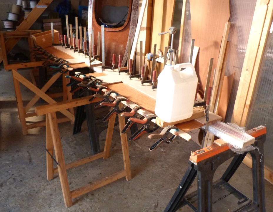 En parall&egrave;le, je colle les renforts ext&eacute;rieurs sur les flancs du puits de d&eacute;rive. Le bidon au premier plan sert &agrave; contrer le vrillage de l'un des flancs : il exerce un pression sur le coin de l'assemblage qui est support&eacute; &agrave; son autre extr&eacute;mit&eacute; par le tr&eacute;teau en bois. L'autre bord est press&eacute; sur la r&egrave;gle en alu (ancienne barri&egrave;re de parking) afin d'assurer sa rectitude. J'ai v&eacute;rifi&eacute; l'horizontalit&eacute; sur la longueur de la pi&egrave;ce &agrave; l'aide de mon niveau &agrave; bulle. 