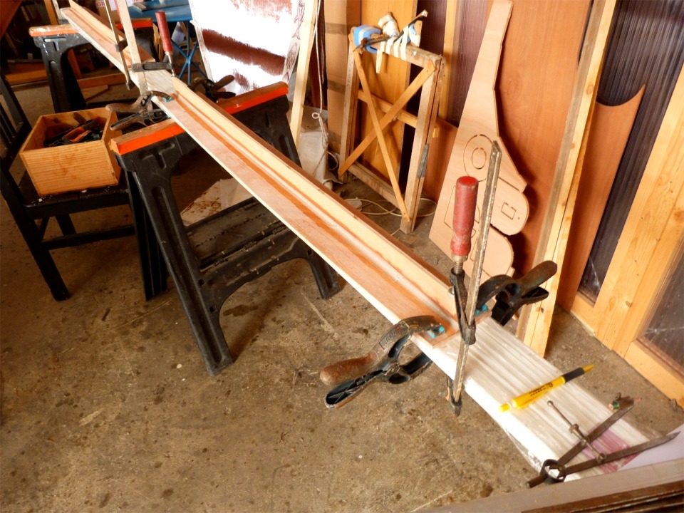 Je colle des raidisseurs (bandes de de contreplaqu&eacute; de 6 mm en 50 mm de large) sur toute la longueur des cloisons longitudinales ext&eacute;rieures des ballasts car elles sont toujours cintr&eacute;es apr&egrave;s leur impr&eacute;gnation &eacute;poxy (malgr&eacute; le pressage sur la r&egrave;gle alu pendant le durcissement). En effet, ces cloisons doivent &ecirc;tre rectilignes pour leur installation, car je n'ai aucune envie de les coudre au bord&eacute; sur toute leur longueur. Les raidisseurs seront sur la face ext&eacute;rieure des ces cloisons, et je pense les couper apr&egrave;s avoir coll&eacute; les cloisons dans la coque. 