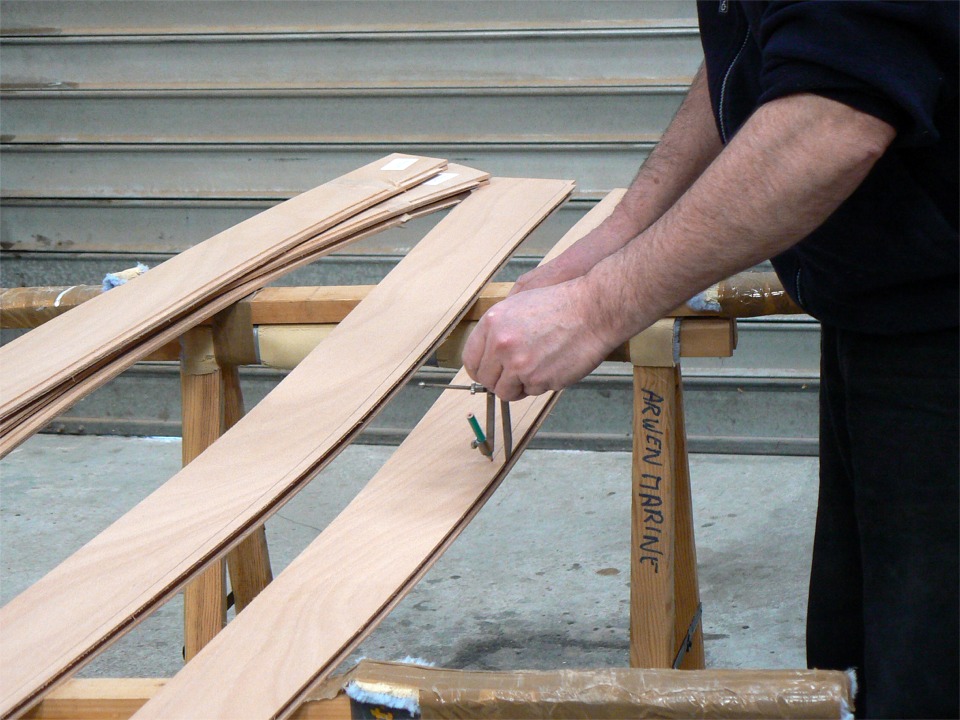 Grâce au compas, je trace tout du long pour positionner les trous des sutures à une distance uniforme du bord de chaque clin, afin qu'elles chevauchent les feuillures. 