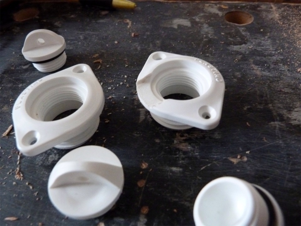 Je donne un coup de lime au bord de ces nables Plastimo, car leur rebord fait 5 mm de haut. Apr&egrave;s traitement (celui de droite), le rebord est r&eacute;duit &agrave; 1.5 mm, ce qui r&eacute;duira l'eau r&eacute;siduelle dans les r&eacute;servoirs de ballast o&ugrave; je vais les utiliser. Je vais aussi remplir la cavit&eacute; des bouchons d'&eacute;poxy charg&eacute;e que j'affleurerai au niveau de la sole afin de r&eacute;duire les trubulences. 