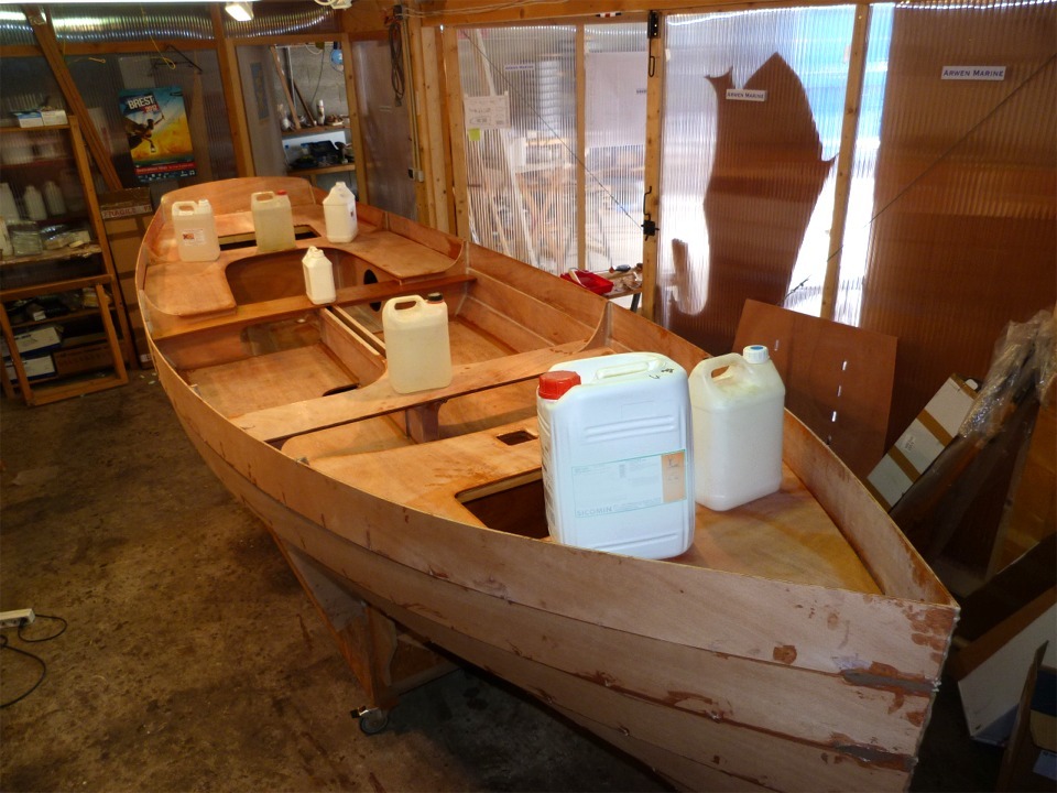 Le lendemain, apr&egrave;s avoir fait les joints-cong&eacute;s des panneaux de la cellule centrale, je passe au collage des deux bancs transversaux et des pontages avant et arri&egrave;re. Je commence par passer une couche d'&eacute;poxy claire sur les parois int&eacute;rieures des caissons, sur la face inf&eacute;rieure des bancs et des pontages, et je tartine d'&eacute;poxy charg&eacute;e tous les chants sur lesquels ces &eacute;l&eacute;ments vont reposer. Je mets tout en place et je distribue les bidons en fonction des besoins de pressage. Je v&eacute;rifie imm&eacute;diatement que les pi&egrave;ces reposent bien sur les chants encoll&eacute;s &agrave; l'aide d'un miroir que je prom&egrave;ne le long de tous les joints cach&eacute;s. 