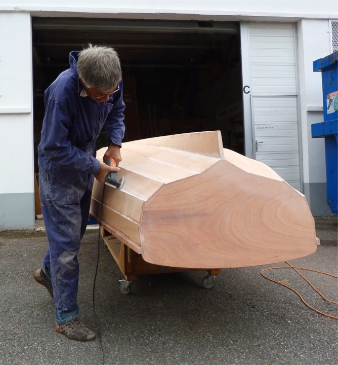 Pierre est venu me pr&ecirc;ter main forte pour deux jours afin de m'aider &agrave; tenter d'&ecirc;tre pr&ecirc;t pour exposer Silmaril au Village Bois du Grand Pavois. Je ne comptais pas y aller mais je me suis presque laiss&eacute; convaincre de la n&eacute;cessit&eacute; d'y aller avec ce bateau tout nouveau. Notez l'&eacute;l&eacute;gance du geste de Pierre &agrave; la ponceuse, tout dans l'appui sur le pied droit. C'est normal : Pierre ponce ! (Vous ne croyiez tout de m&ecirc;me pas que j'allais la laisser perdre). 