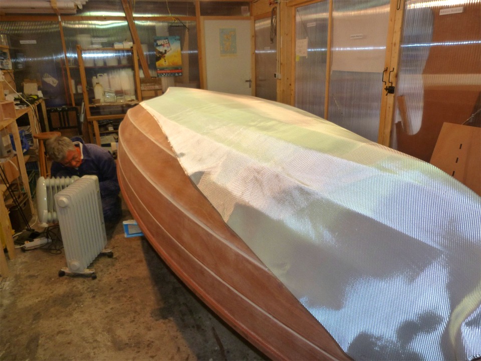 Apr&egrave;s un d&eacute;poussi&eacute;rage complet, nous rentrons le bateau et drapons le tissu de 300 g/m2. Pierre est occup&eacute; &agrave; glisser le petit radiateur sous la coque afin de la garder au chaud pendant la nuit prochaine. 