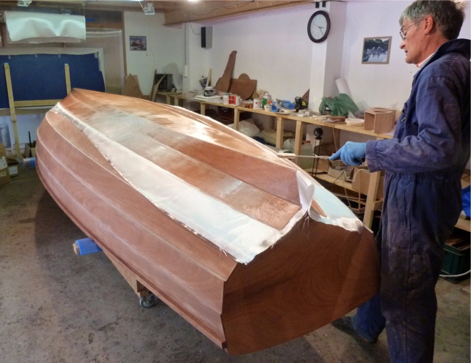 Pierre apporte la derni&egrave;re touche &agrave; la saturation du tissu de verre, que nous avons faite au rouleau. Nous allons ensuite couper tout le tissu non satur&eacute;, au-dela du joint entre les virures 2 et 3. 