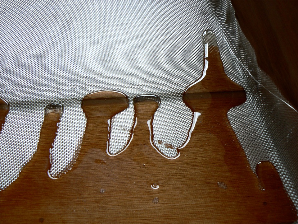 Je fais la stratification sur l'intérieur du Wherry d'Annapolis. Ici, je viens de verser un peu de résine époxy sur le tissu, et je vais ensuite l'étaler et la faire pénétrer à la raclette. 