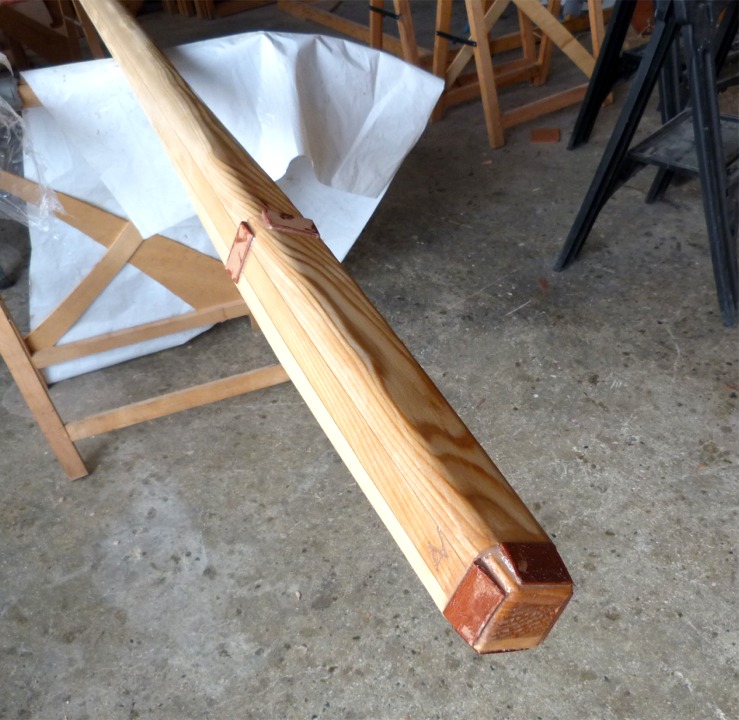 Je termine en passant une couche d'&eacute;poxy sur le m&acirc;t ponc&eacute;, et en collant des cales d'&eacute;tambrai et de pied en contreplaqu&eacute; makor&eacute; (tr&egrave;s dur) et profil&eacute;es en biseau. L'int&eacute;r&ecirc;t de ces cales est d'amener le m&acirc;t &agrave; la section pr&eacute;cise des ouvertures de l'&eacute;tambrai et du pied afin qu'il tienne bien en place. La duret&eacute; du makor&eacute; assure qu'il ne "collrae" pas lorsqu'il sera temps de d&eacute;m&acirc;ter. 