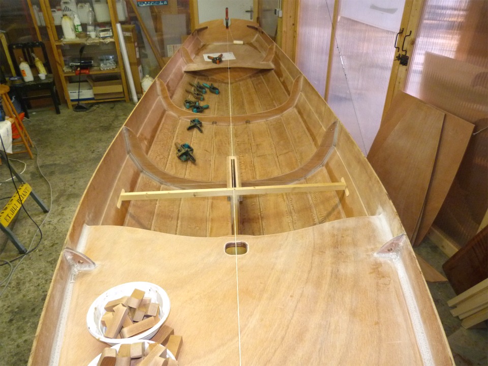 Retour sur la Yole de Chester pour le montage du puits de d&eacute;rive. J'ai tendu un cordeau pour mat&eacute;rialiser l'axe de la coque, et j'ai &eacute;galement viss&eacute; un tasseau transversal sur l'avant du puits de d&eacute;rive afin de m'assurer que le puits soit &agrave; la fois dans l'axe et vertical. 