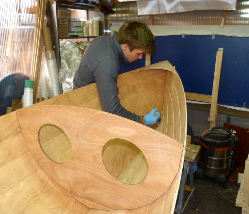 Le moment est venu de passer au "coll&eacute;" de "cousu-coll&eacute;" ! Sur cette image, Mattias d&eacute;pose &agrave; la seringue un gros cordon d'&eacute;poxy charg&eacute;e &agrave; la consistance de la cr&egrave;me de marrons dans l'&eacute;trave. En effet, nous commen&ccedil;ons par coller l'&eacute;trave, le tableau et les deux cloisons, seulement sur leur face int&eacute;rieure. 