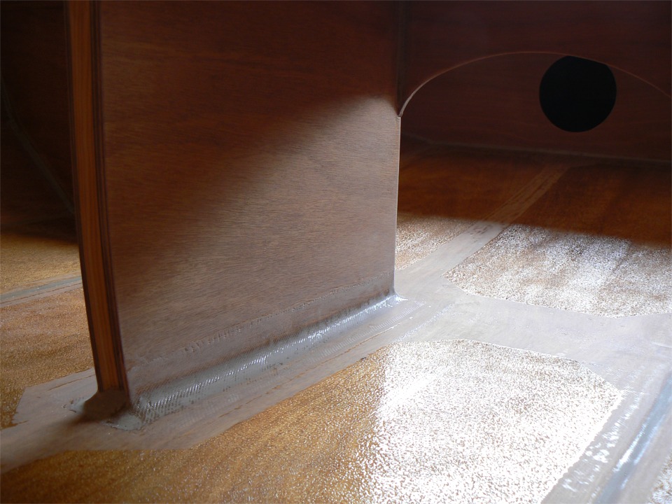 Vue du fond de la coque apr&egrave;s avoir appliqu&eacute; l'&eacute;poxy et les microbilles, puis arrach&eacute; l'adh&eacute;sif. On voit clairement le gros joint-cong&eacute; "arm&eacute;" du bas du puits de d&eacute;rive. Vue depuis l'avant... 