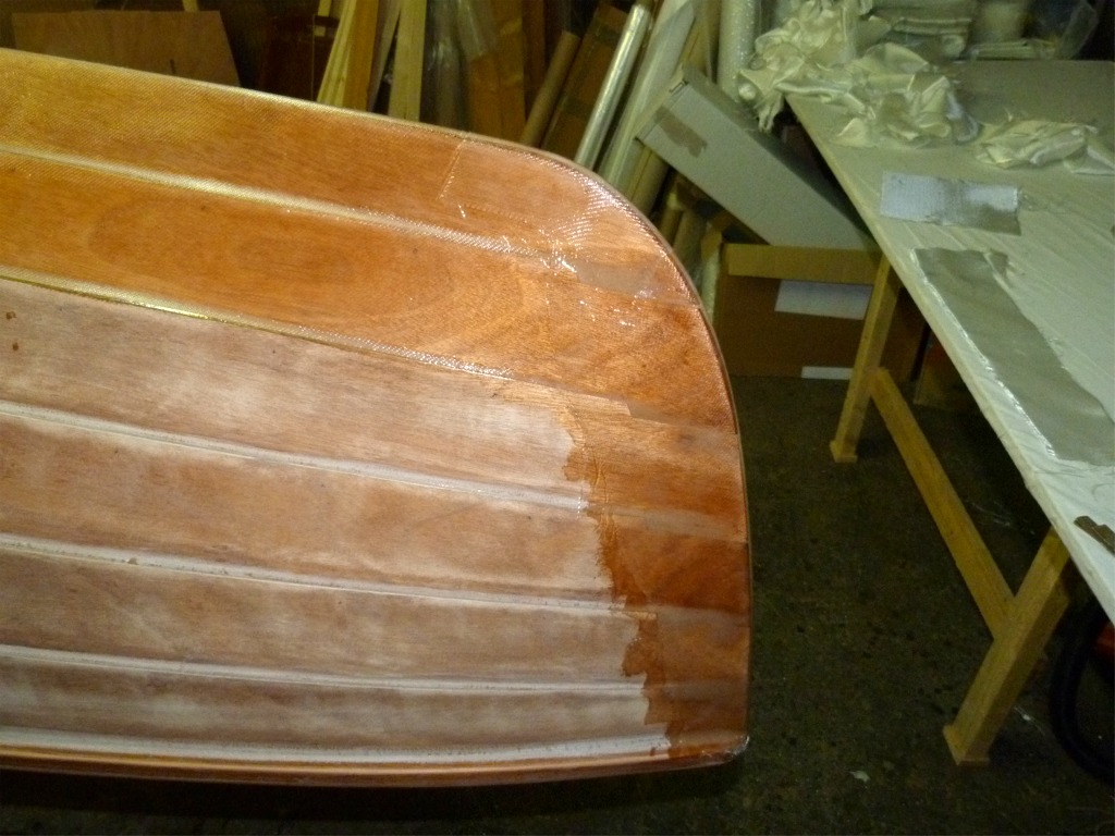 Une bande de fibre de verre enveloppe l'&eacute;trave de bas en haut, avec un l&eacute;ger recouvrement sur la stratification des bord&eacute;s de fond, avec une troisi&egrave;me pi&egrave;ce plus petite couvrant le brion, &agrave; la jonction des deux pi&egrave;ces principales. 