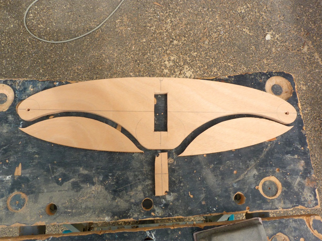 Je me suis d&eacute;cid&eacute; &agrave; adopter le syst&egrave;me de barre brevet&eacute; de Pierre, avec un palonnier sym&eacute;trique &agrave; deux drosses, au lieu du timon scandinave que j'avais initialement choisi, car j'aurais d&ucirc; lui adjoindre un stick de 2.40 m de long, bien encombrant et fragile (ou lourd), pour pouvoir barrer &agrave; partir du centre de gravit&eacute; de la yole. Je d&eacute;coupe ce palonnier dans une chute : c'est la pi&egrave;ce lib&eacute;r&eacute;e par l'all&egrave;gement de la membrure centrale d'un Skerry. Je commence d'ailleurs &agrave; &eacute;touffer sous les chutes car "&ccedil;a peut toujours servir, on ne va quand-m&ecirc;me pas jeter &ccedil;a" conduit &agrave; remplir tous les coins de l'atelier de morceaux de contreplaqu&eacute; plus ou moins petits et des formes les plus diverses. Pierre m'a tordu le bras jusqu'&agrave; ce je trie et range une partie de mon tr&eacute;sor, car il ne trouvait plus les outils... 