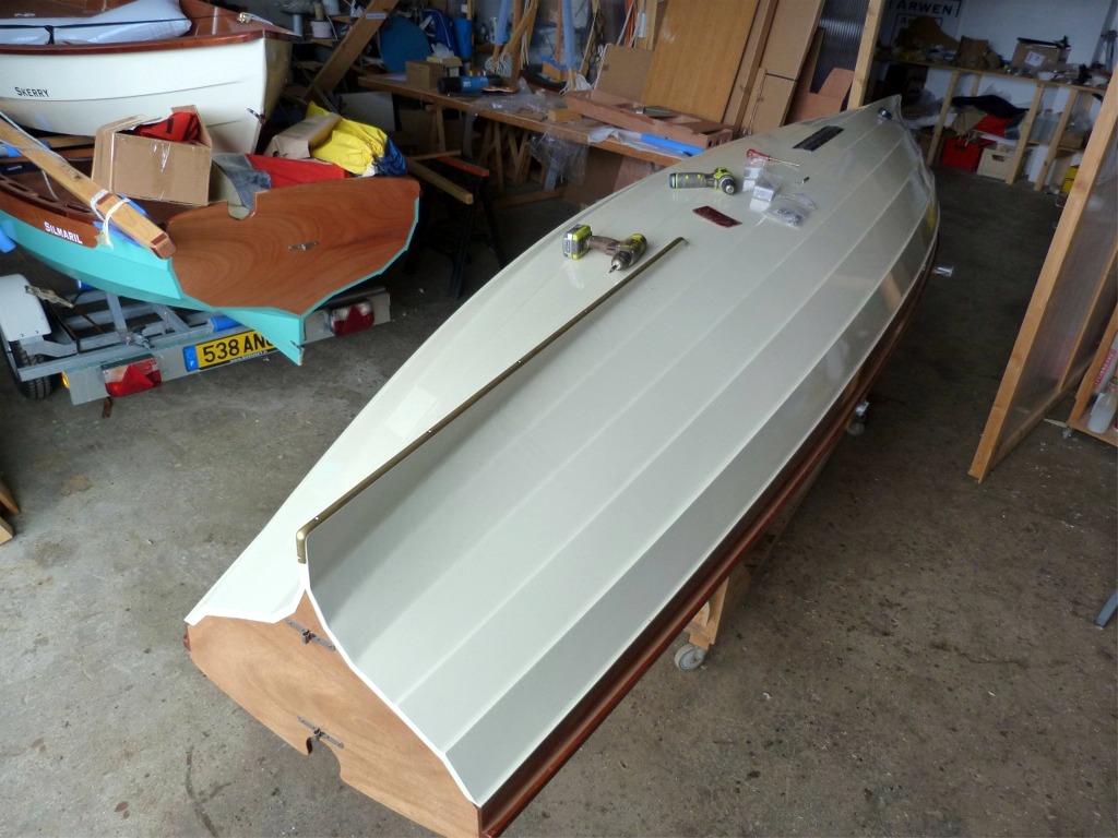 Retour &agrave; l'atelier : je m'attaque aux finitions sur "ma" yole. Ici je pose la bande-molle en profil&eacute; demi-ovale de laiton. Le moment d&eacute;licat de cette op&eacute;ration est le cintrage du profil&eacute;, qui doit se conformer au contour de l'aileron. Je me dis qu'il serait plus facile de cintrer le profil avant la peinture, alors qu'il est encore possible de passer un coup de rabot ou de ponceuse &agrave; bande pour ajuster l'arrondi de l'une ou l'autre des extr&eacute;mit&eacute;s de l'aileron... 