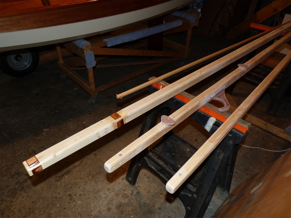 Tous mes espars sont pr&ecirc;ts pour le vernis, apr&egrave;s un dernier pon&ccedil;age partiel sur les cales d'&eacute;tambrai et de pied de m&acirc;t. On aper&ccedil;oit sur la b&ocirc;me l'encornat lat&eacute;ral et les deux plaquettes qui recevront les coinceurs de mon syst&egrave;me de prise de ris semi-automatique : une bosse de ris unique frapp&eacute;e sur la b&ocirc;me au point d'amure et au point d'&eacute;coute passe par les deux oeillets du guindant et de la chute, revient sur deux poulies fixes et passe dans les deux coinceurs plac&eacute;s &agrave; 30 cm en avant et en arri&egrave;re du m&acirc;t, sous la b&ocirc;me. 