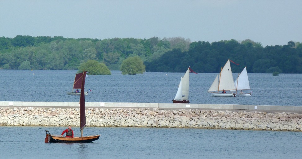 Le PassageMaker Dinghy Joli Jeanlin croise la flotille qui progresse dans la direction opposée, de l'autre coté de la digue du port du Mesnil-St-Père. 