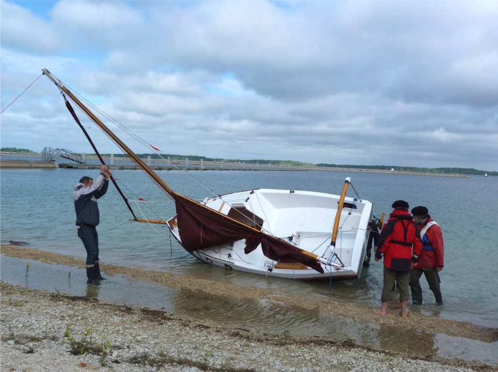 La dérive du PocketShip ZO s'est trouvée coincée par des petits cailloux entrées dans le puits et Bruno extrait son pivot afin de la libérer, tandis que le bateau est abattu en carène. 