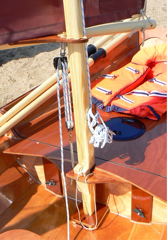 La b&ocirc;me pivote sur le m&acirc;t gr&acirc;ce &agrave; cet "encorn&acirc;t" fourr&eacute; en cuir, et le palan fait &agrave; la fois office d'amure et de hale-bas de b&ocirc;me, et nous avons ainsi pu v&eacute;rifier que celle-ci ne "m&acirc;te" pas au vent arri&egrave;re, ce qui est le gros d&eacute;faut des voiles au tiers. La grosse cale d'&eacute;tambrai (avec sa laisse de s&ucirc;ret&eacute;) rend le m&acirc;tage/d&eacute;m&acirc;tage tr&egrave;s facile : sans la cale, l'&eacute;tambrai est grand ouvert et le m&acirc;t circule facilement.. 