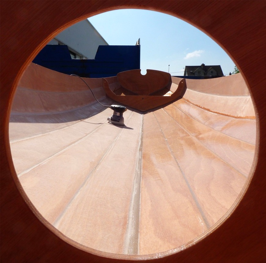 Le lendemain, je sors la Yole de Chester pour d&eacute;polir la surface de la zone stratifi&eacute;e afin de pouvoir coller les membrures puis passer une nouvelle couche d'&eacute;poxy sur toute la surface int&eacute;rieure. J'ai fait cette photo alors que j'ai d&eacute;j&agrave; ponc&eacute; sur tribord. 