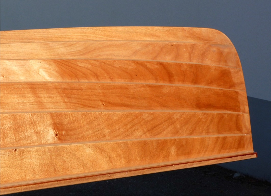 Cette photo du profil de la proue montre la d&eacute;licatesse de son trac&eacute;. Notez que les deux virures du fond (en haut sur l'image) et l'&eacute;trave sont plus claires car la fibre de verre garde une l&eacute;g&egrave;re opacit&eacute; qui se r&eacute;v&egrave;le sous un fort &eacute;clairage.