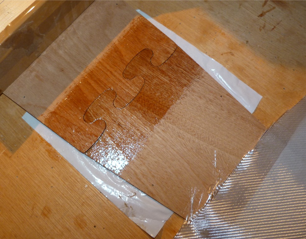 Je commence par appliquer une couche d'époxy sur la zone du joint-puzzle, sur une largeur d'une dizaine de centimètres. Notez que j'ai glissé un bout de film plastique sous le joint afin d'éviter de rester collé à la table (ce qui serait une situation embarrassante). 