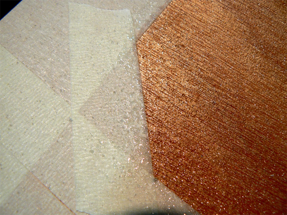 Je passe une première couche d'époxy à l'intérieur du masquage, puis je saupoudre dessus des microbilles de verre qui se fixent dans l'époxy fraîche. Une seconde couche d'époxy par dessus immobilisera définitivement les microbilles et atténuera leur "mordant". 