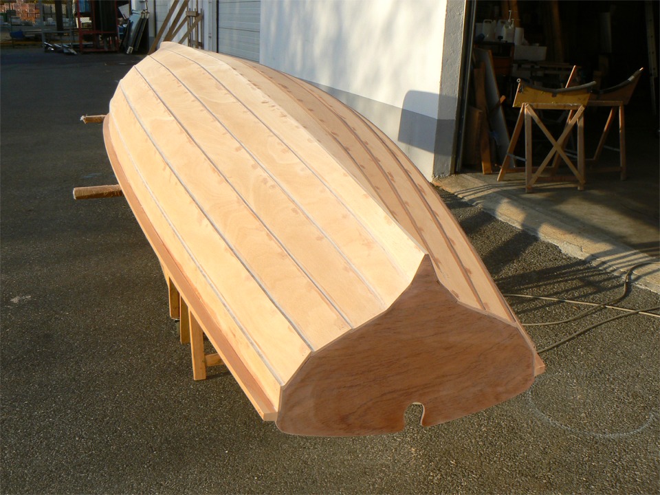 J'ai ensuite arrondi le coin haut ext&eacute;rieur des listons &agrave; la d&eacute;fonceuse, avec une fraise &agrave; guide en quart de rond., puis j'ai retourn&eacute; la yole avec l'aide de mon irrempla&ccedil;able Igor, et j'ai ponc&eacute; tout l'ext&eacute;rieur en vue de la stratification du fond. 