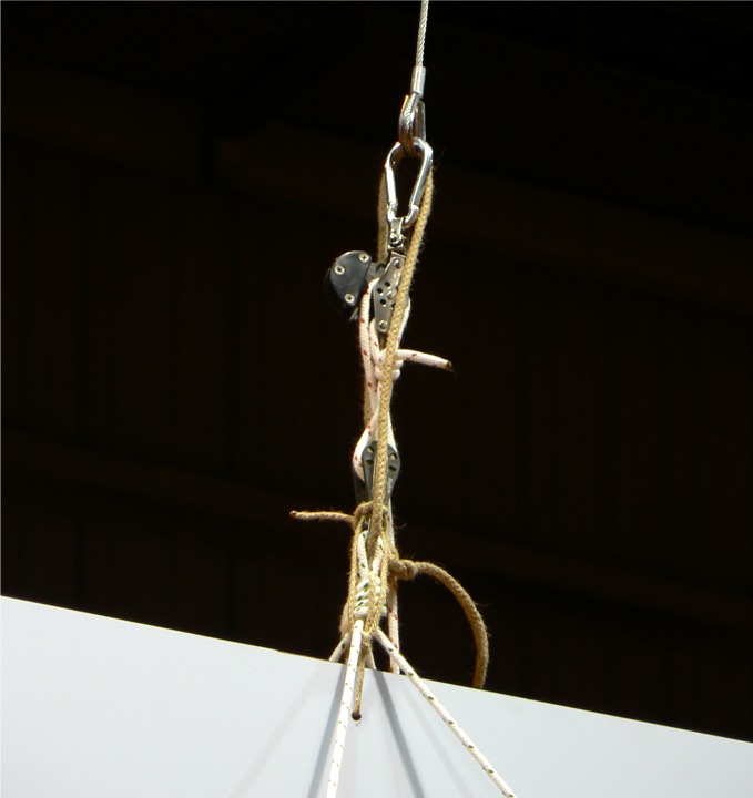 Les &eacute;lingues en c&acirc;ble &eacute;taient install&eacute;es par l'organisateur du salon, et nous avons frapp&eacute; sur chacune un palan simple avec un coinceur sur la poulie du haut, comportant &eacute;galement un ringot. Une fois la Yole hiss&eacute;e gr&acirc;ce aux palans, nous avons pass&eacute; un petit bout dans l'oeil de l'&eacute;lingue et dans l'estrope cot&eacute; Yole afin de s&eacute;curiser l'amarrage. 