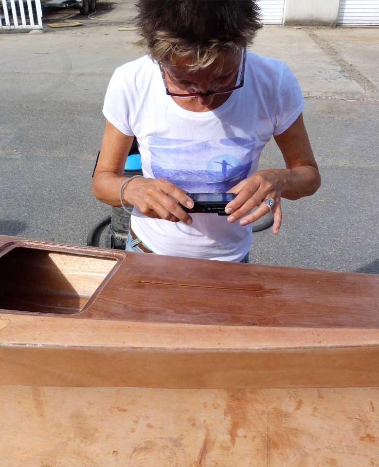 Annick prend une photo &agrave; travers la fente du puits de d&eacute;rive. 