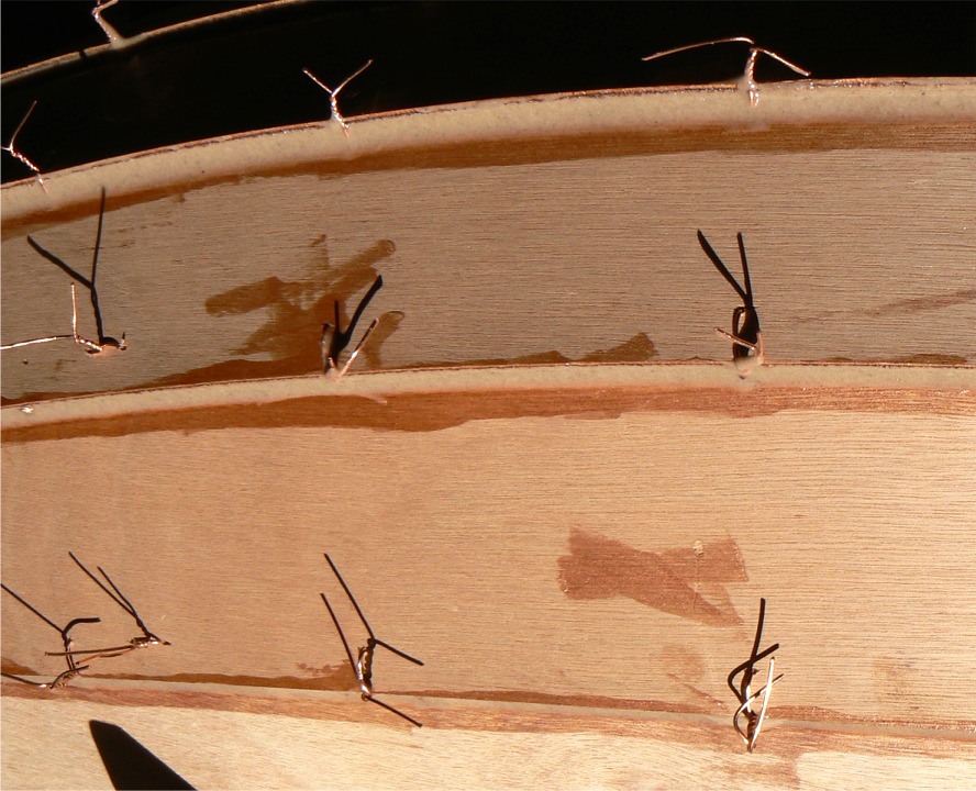 Premier collage des bordés par l'extérieur. Au lieu de faire ce premier collage "en pointillés" entre les sutures, j'ai fait tout de suite un collage continu, en prenant le parti de chauffer systématiquement ces dernières pour les extraire. Le rebouchage des trous qu'elles laissent se fait aisément en passant une seconde couche sur tous les joints. 