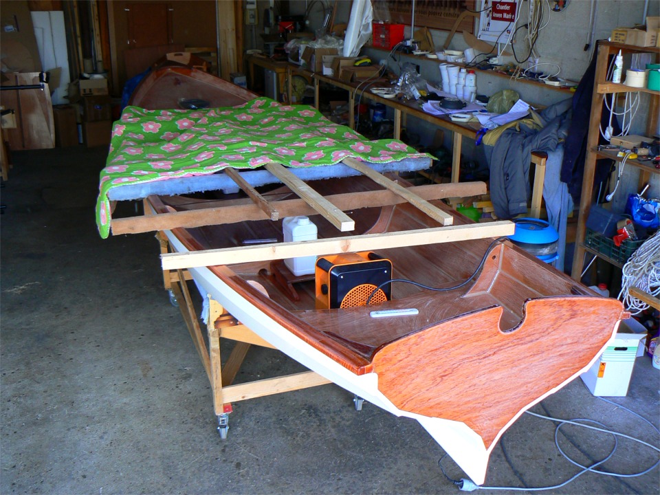 Je continue &agrave; employer des ruses d'indien pour faire durcir l'&eacute;poxy : le thermom&egrave;tre oscille entre 7 et 9 degr&eacute;s dans l'atelier. Sur cette image, je colle les sabots sur lesquels s'appuieront les pieds du Piantedosi dans le fond de la Yole de Chester. Un radiateur &eacute;lectrique &agrave; chaque bout, quelques bouts de bois et mes fameux duvets &agrave; fleurs pour garder la chaleur. 