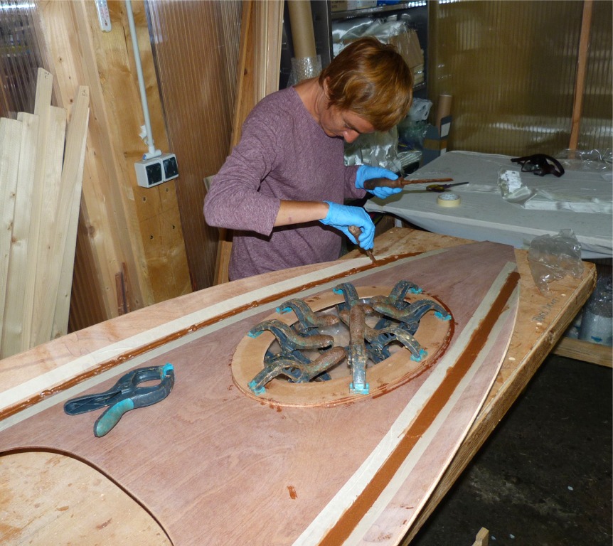 Nous d&eacute;posons &agrave; la seringue un filet d'&eacute;poxy que nous lissons ensuite &agrave; l'aide d'un vieux ciseau &agrave; bois ou d'un couteau &agrave; mastic. Nous venons de coller la structure de support de la trappe, comme en t&eacute;moignent les pinces. 