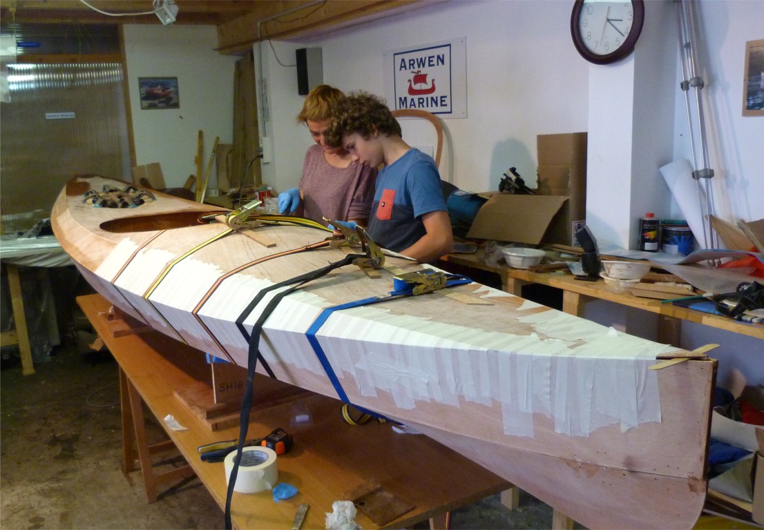 Nous r&eacute;unissons de nouveau la coque et le pont, car il est imp&eacute;ratif que les joints que nous venons de faire durcissent dans une conformation compatible au niveau du joint du livet, qui r&eacute;unit la coque et le pont. Notez l'abondance d'adh&eacute;sif et les sangles : la suppression du couple temporaire du pont sur l'avant de l'ouverture du cockpit provoque un "retour" et il faut donc employer des arguments s&eacute;rieux pour ramener les bords du pont sur ceux de la coque &agrave; cet endroit. 