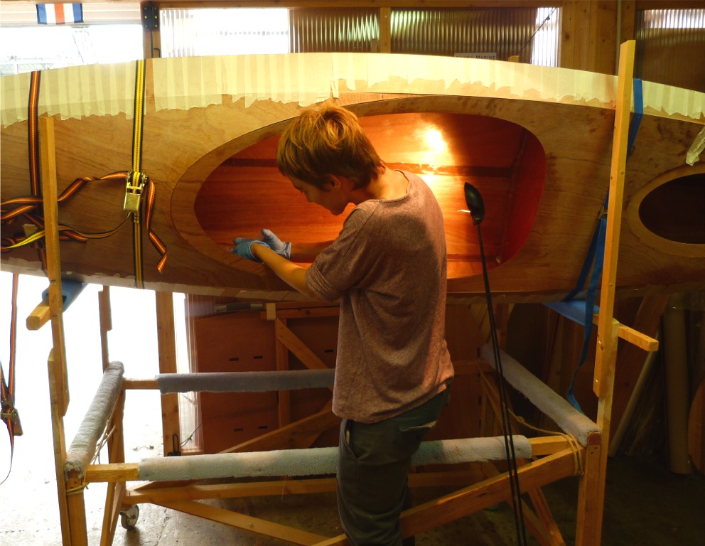 Maud utilise une seringue pour d&eacute;poser l'&eacute;poxy charg&eacute;e dans le joint sur la zone du cockpit. Dans la pointe avant, nous utiliserons une cuiller au bout d'un long manche pour d&eacute;poser et lisser l'&eacute;poxy jusque dans l'&eacute;trave. 