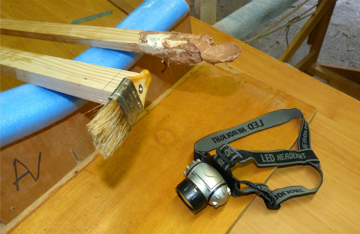 Voici les trois outils de base pour la r&eacute;alisation du joint pont-coque : la lampe frontale, la cuiller et le pinceau mont&eacute;s sur un manche d'un m&egrave;tre de long. La cuiller sert &agrave; d&eacute;poser et lisser l'&eacute;poxy charg&eacute;e et le pinceau sert &agrave; pousser le rouleau de bande de fibre de verre pour le d&eacute;rouler sur le joint, puis &agrave; lisser la fibre de verre pour &eacute;liminer les bulles d'air. 