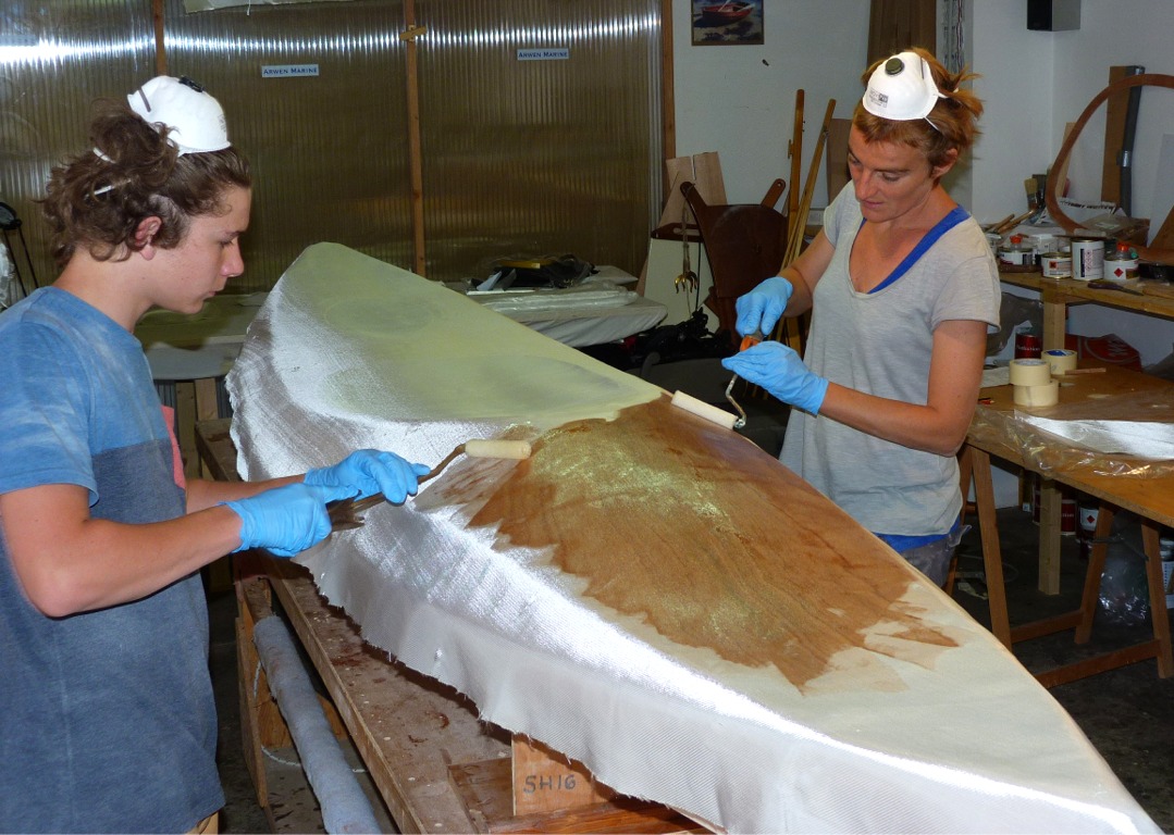 Nous enchaînons avec la stratification du pont. Nous avons drapé une pièce de tissu de verre sur la zone à stratifier, et saturons le tissu au rouleau. 