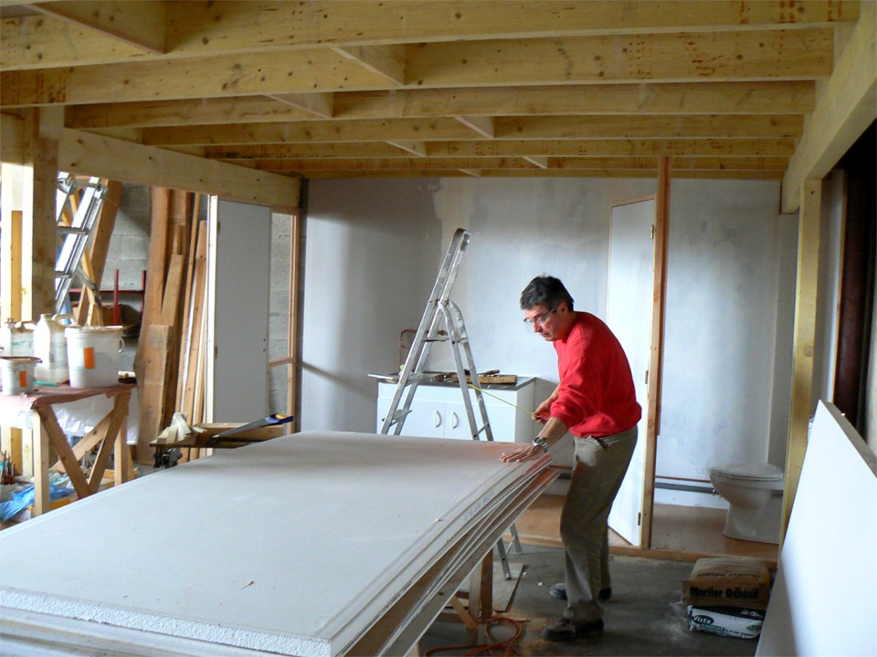 Nous continuons avec Dominique les am&eacute;nagements &agrave; l'atelier commenc&eacute;s la semaine derni&egrave;re. Ici Dominique reporte une cote sur un panneau de pl&acirc;tre, alors qu'on aper&ccedil;oit derri&egrave;re lui la nouvelle zone du "life support" : toilettes &agrave; droite et &eacute;vier &agrave; gauche. L'&eacute;vier sera bient&ocirc;t rejoint par un embryon de cuisine avec r&eacute;frig&eacute;rateur, cafeti&egrave;re et micro-ondes, un luxe extravagant. Les blocs-porte sont d&eacute;j&agrave; fix&eacute;s mais &ccedil;a manque encore un peu de cloisons...