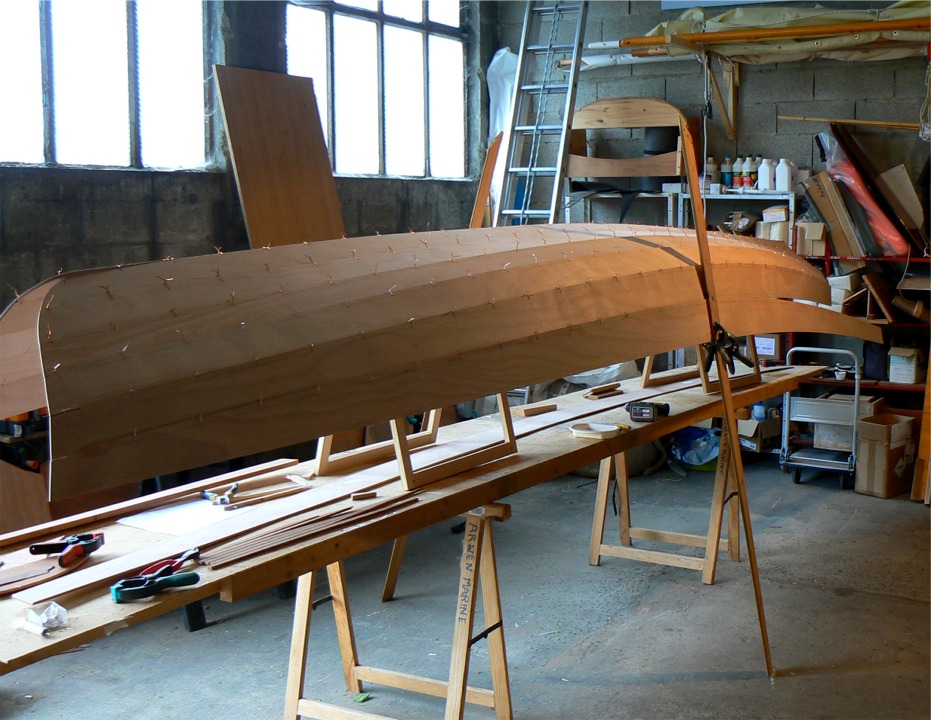 Je retourne &agrave; des trucs moins risqu&eacute;s : sixi&egrave;me bord&eacute; sur la Yole de Chester. Je me sers des "b&eacute;quilles" que l'on voit ici pour soutenir l'ouverture de la coque et pour tenir le bord&eacute; en cours de couture. 