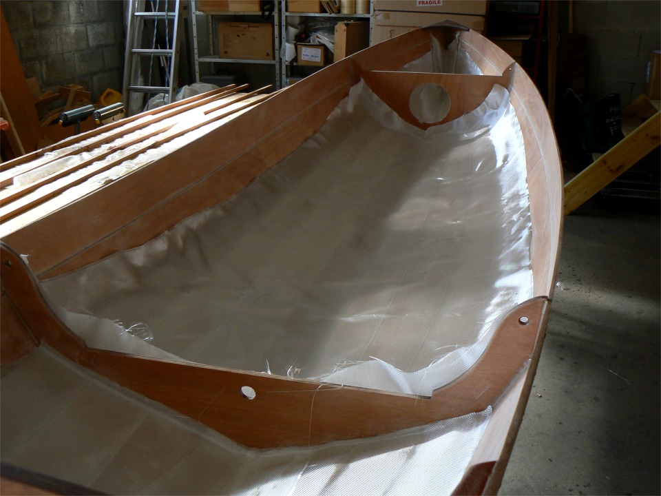 Apr&egrave;s le stade "loukoum", j'ai pass&eacute; l'aspirateur, puis un chiffon imbib&eacute; d'alcool pour ramasser le peu de poussi&egrave;re qui restait sur la surface. Que nenni ! J'ai &eacute;t&eacute; sid&eacute;r&eacute; par la quantit&eacute; de poussi&egrave;re que j'ai encore ramass&eacute;e sur le chiffon ! J'ai ensuite drap&eacute; le tissu de verre sur le bord&eacute;, et d&eacute;cid&eacute; de stratifier 8 bord&eacute;s au lieu de 6 car mon tissu est assez large : "trop fort n'a jamais manqu&eacute;"! Ce modeste surcro&icirc;t de poids vaut bien le gain de rigidit&eacute; et de robustesse. 