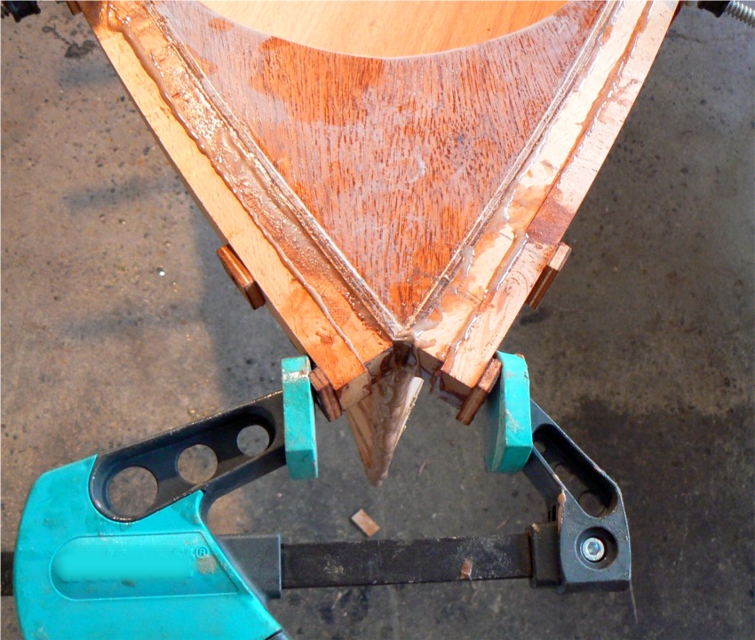 J'ai viss&eacute; des cales aux extr&eacute;mit&eacute;s avant des seconds plis des listons afin de les serrer &agrave; l'aide de ce serre-joint rapide. Les cales sont viss&eacute;es dans la partie du liston qui sera coup&eacute;e &agrave; la finition. Les vis du second plis sont temporaires, et elles sont 8 cm plus loin, ce qui laisse la place pour arrondir l'avant des listons. Je "tamponnerai" les trous de ces vis pour qu'on ne les voie plus, apr&egrave;s avoir remplac&eacute; ces vis temporaires par des vis inox. 