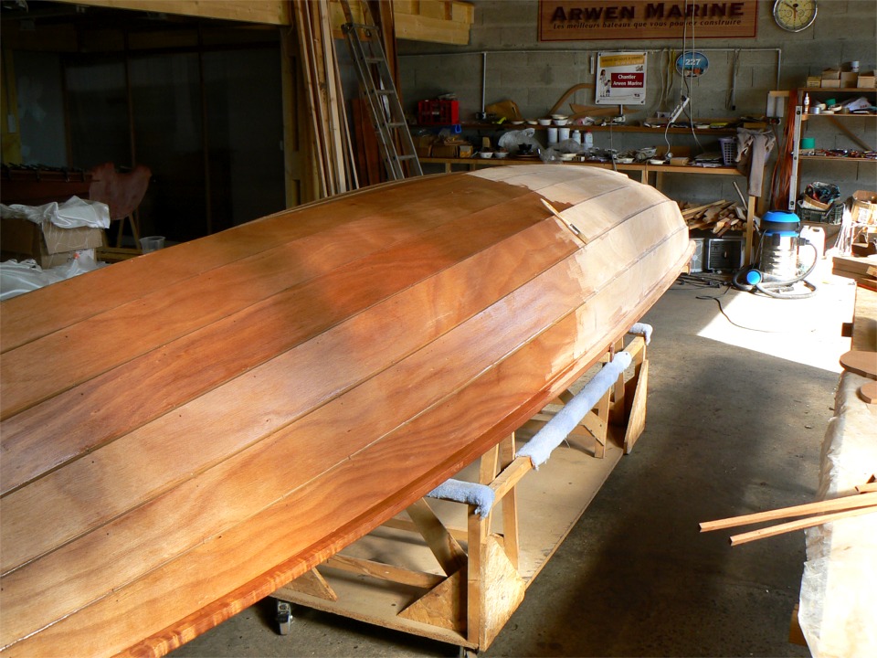 Puis je passe une couche d'impr&eacute;gnation &eacute;poxy. Notez la diff&eacute;rence de teinte et d'intensit&eacute; du veinage de l'okoum&eacute; entre la partie impr&eacute;gn&eacute;e et celle qui est encore brute. 