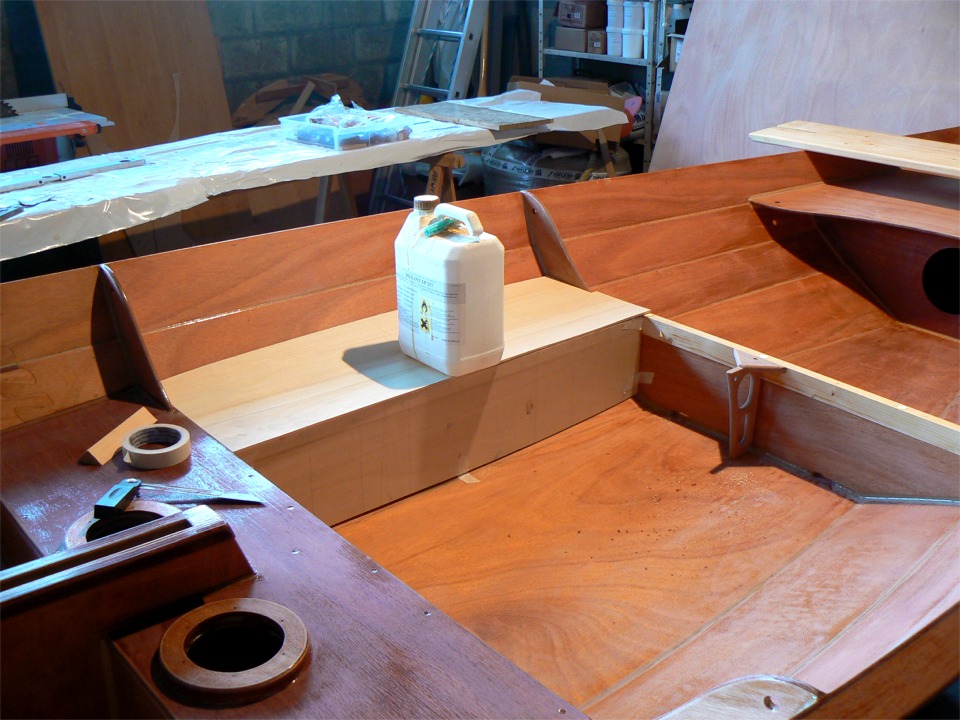 Je me suis décidé à ajouter des bancs latéraux entre les membrures 2 et 3 afin qu'il soit possible de s'assoir pour barrer à la voile. Cette image montre l'essayage des gabarits du flanc et de l'assise du banc tribord. L'étrange appendice que l'on aperçoit sur la face avant de la membrure 3 est la pièce d'ancrage du palan d'écoute. En effet, les bancs en pin seront juste vissés et resteront amovibles, alors que cet ancrage sera collé à la membrure. 