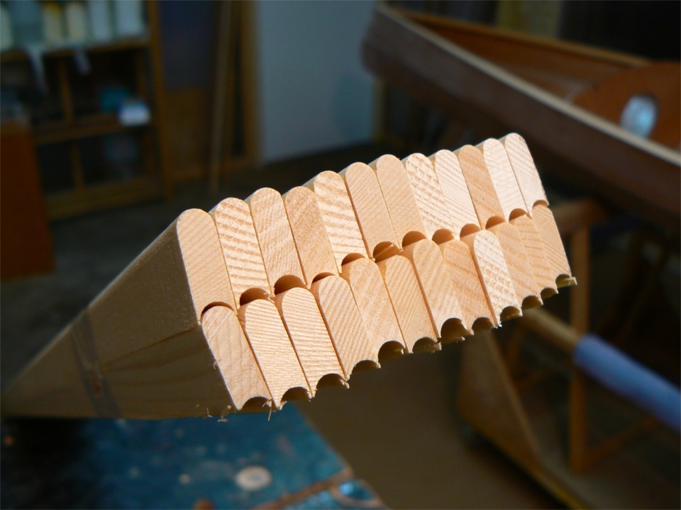 Je commence &agrave; d&eacute;baller les lattes bouvet&eacute;es qui vont me servir &agrave; faire le pont. Le bouvetage (&agrave; la toupie) cr&eacute;e un arc de cercle sur chacun des deux petits cot&eacute;s des lattes : un convexe et un concave (mn&eacute;motechnique : concave = en creux; le convexe c'est l'autre). De la sorte, les lattes peuvent &ecirc;tre juxtapos&eacute;es sans laisser le moindre "jour", quelle que soit l'incidence de l'angle entre deux lattes, et m&ecirc;me si celle-ci est variable sur la longueur du joint.